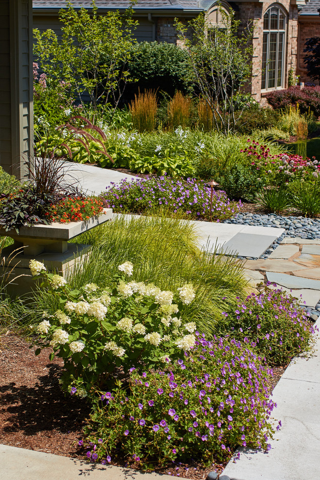 На фото: солнечный, летний засухоустойчивый сад среднего размера на переднем дворе в стиле ретро с садовой дорожкой или калиткой, хорошей освещенностью и покрытием из каменной брусчатки