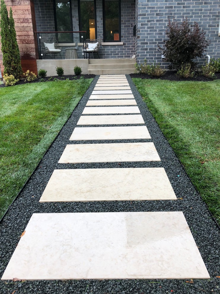 Photo of a small modern front formal full sun garden for summer in Chicago with a garden path and natural stone paving.