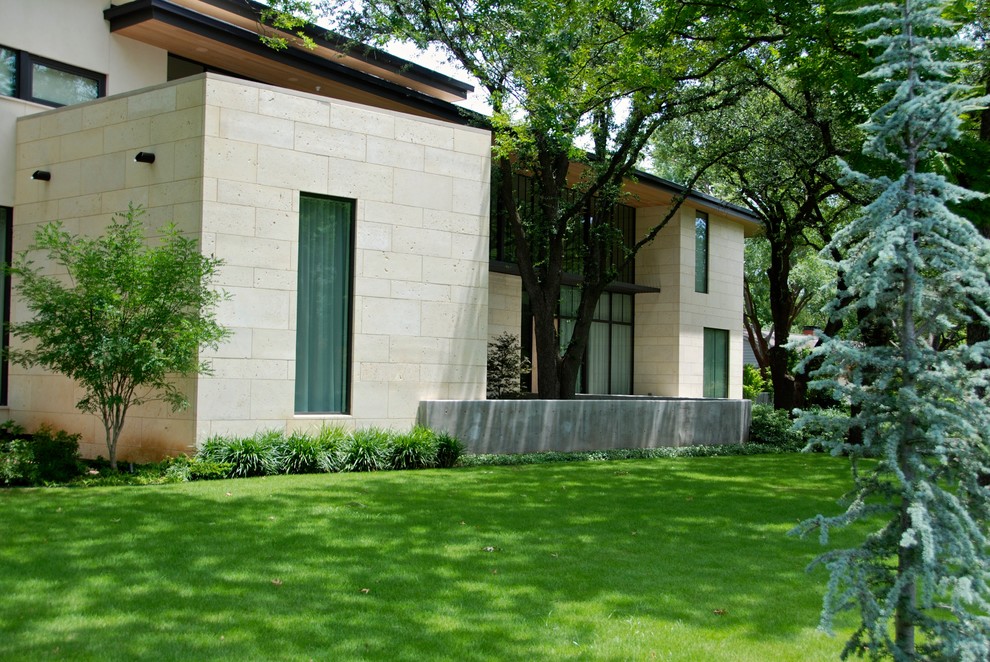 Foto di un grande giardino moderno esposto a mezz'ombra davanti casa con un muro di contenimento