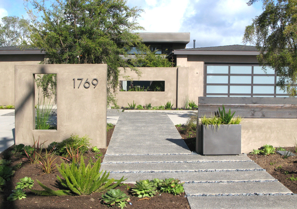 Modelo de jardín contemporáneo en patio delantero con adoquines de hormigón