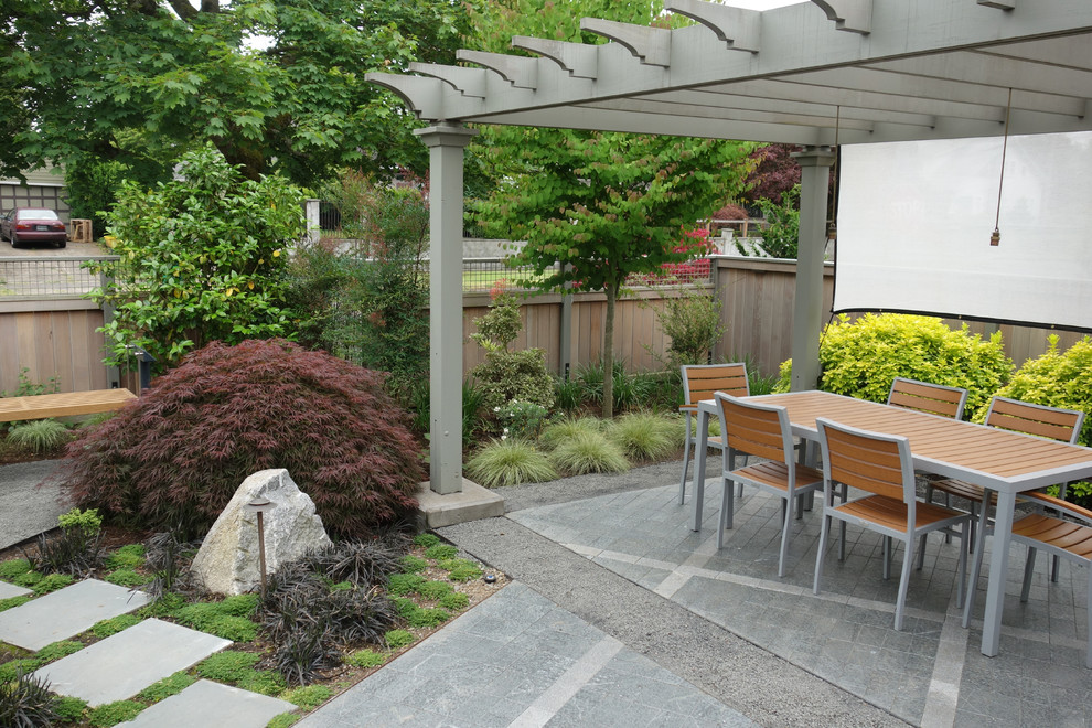 Ejemplo de jardín urbano de tamaño medio en verano en patio trasero con jardín francés, exposición parcial al sol y adoquines de hormigón