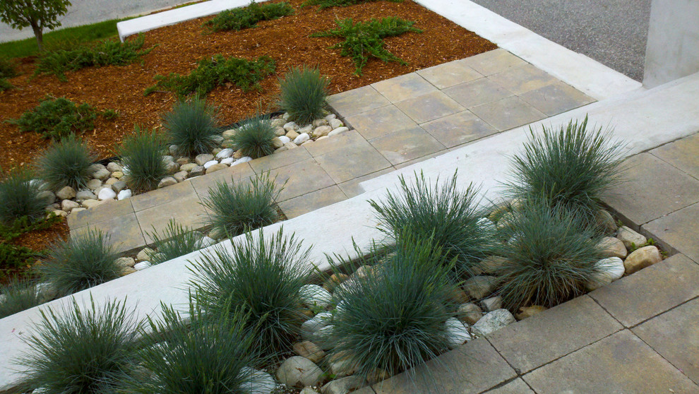 Cette image montre un aménagement d'entrée ou allée de jardin avant design de taille moyenne et l'été avec une exposition ensoleillée et des pavés en béton.