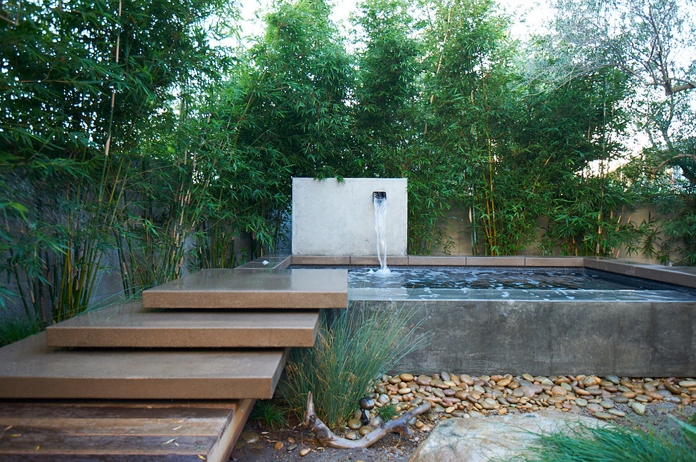 This is an example of a mid-sized modern partial sun backyard water fountain landscape in San Diego for spring.