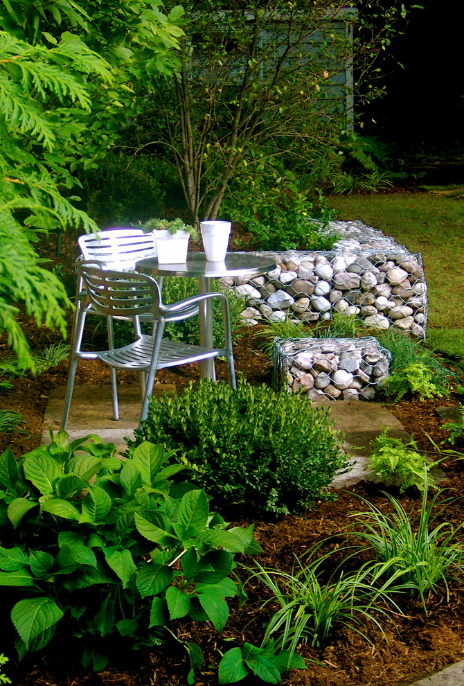 Cette photo montre un petit jardin arrière chic avec une exposition partiellement ombragée et des pavés en béton.