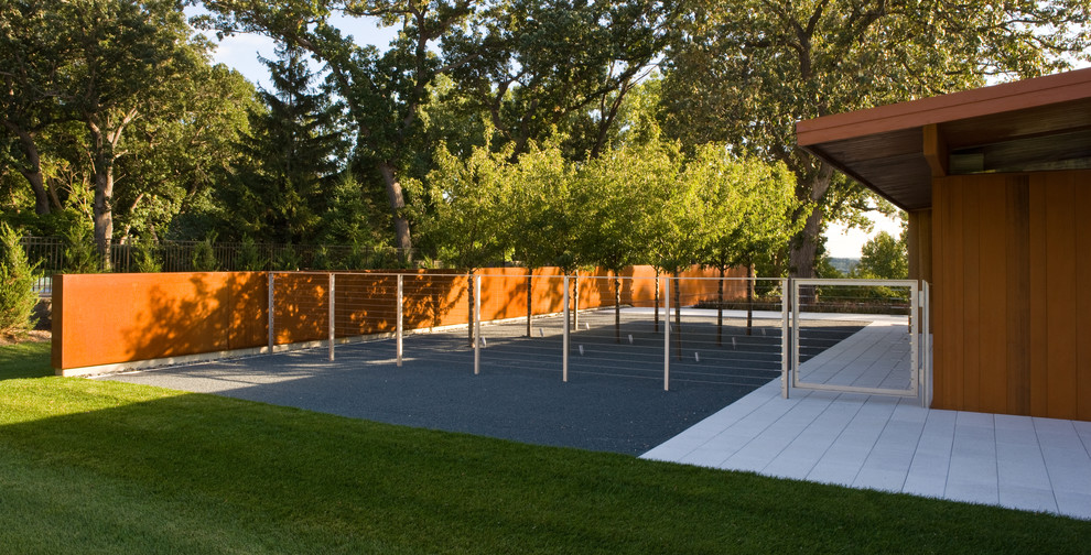 Inspiration pour un jardin latéral minimaliste de taille moyenne avec un mur de soutènement et des pavés en béton.