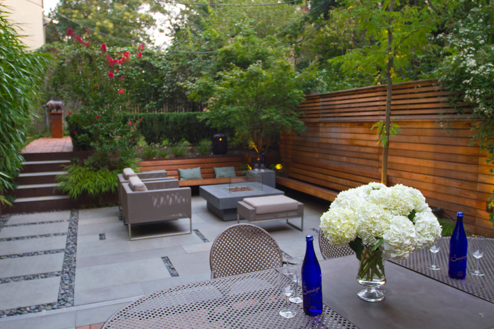 Inspiration for a modern back garden in New York with a fire feature and concrete paving.