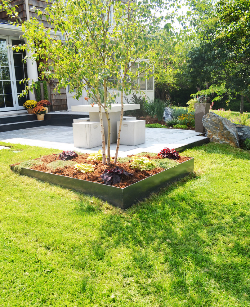 Réalisation d'un jardin arrière design de taille moyenne avec une exposition partiellement ombragée et des pavés en pierre naturelle.