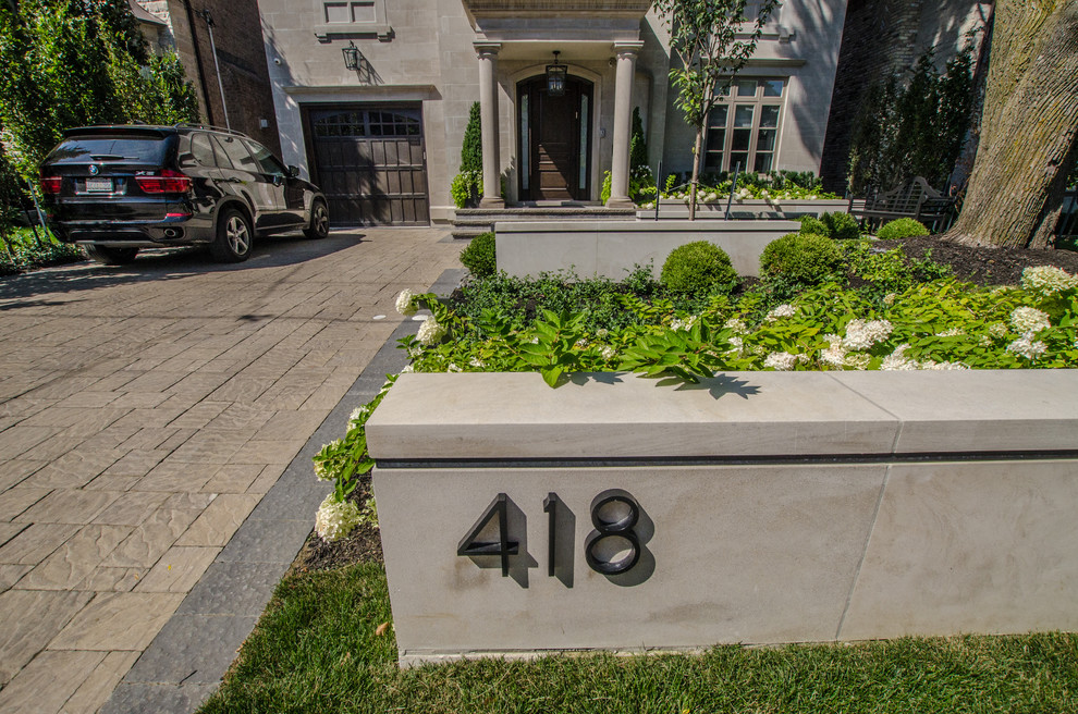 This is an example of a mid-sized contemporary full sun front yard concrete paver landscaping in Toronto for summer.