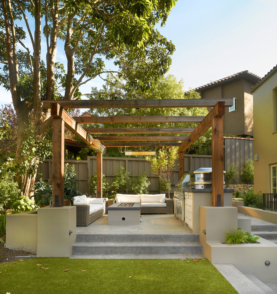 Immagine di un giardino di medie dimensioni e dietro casa in estate con un focolare e pavimentazioni in pietra naturale