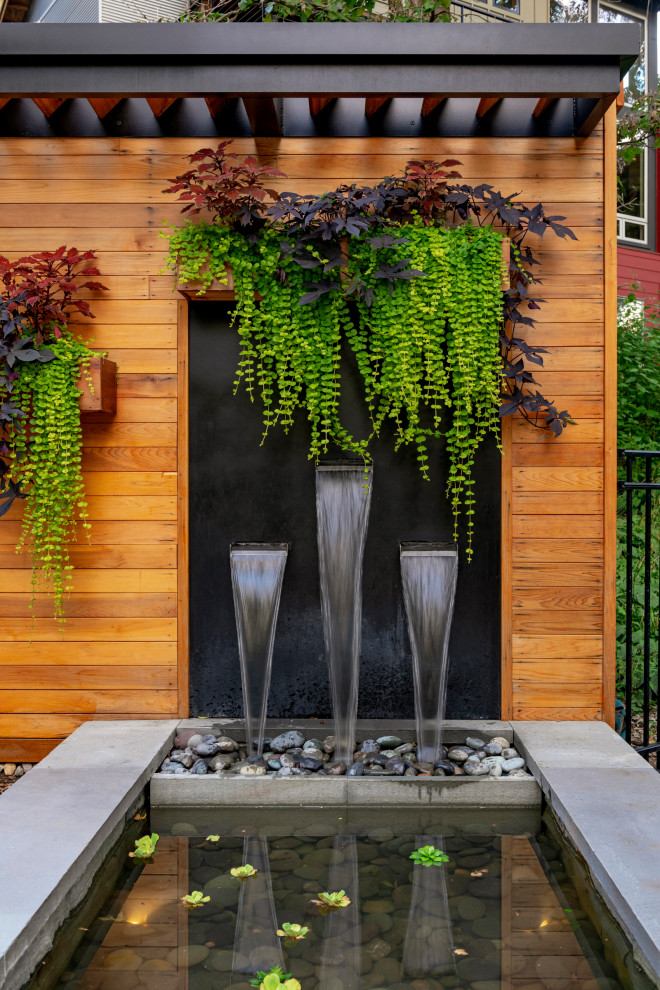 Mittelgroßer, Halbschattiger Moderner Gartenwasserfall im Sommer, hinter dem Haus mit Natursteinplatten in Minneapolis