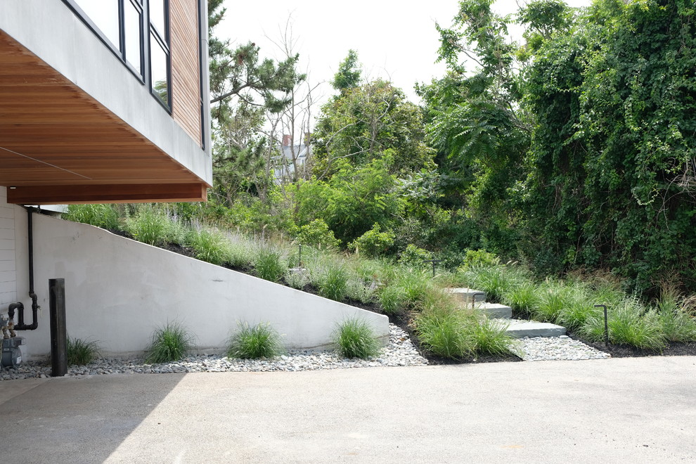 Réalisation d'un grand jardin minimaliste l'été avec une exposition ensoleillée, une pente, une colline ou un talus et des pavés en pierre naturelle.