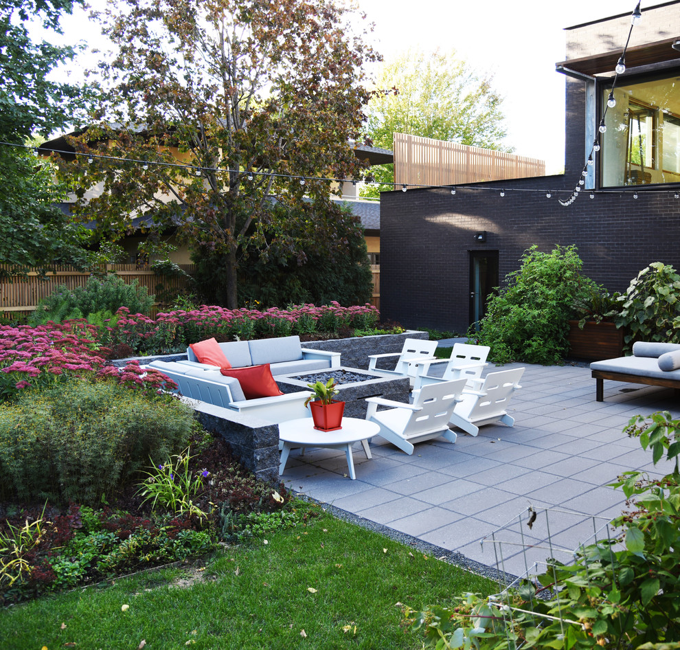 Immagine di un piccolo giardino xeriscape minimalista esposto in pieno sole dietro casa in estate con un focolare e pavimentazioni in pietra naturale