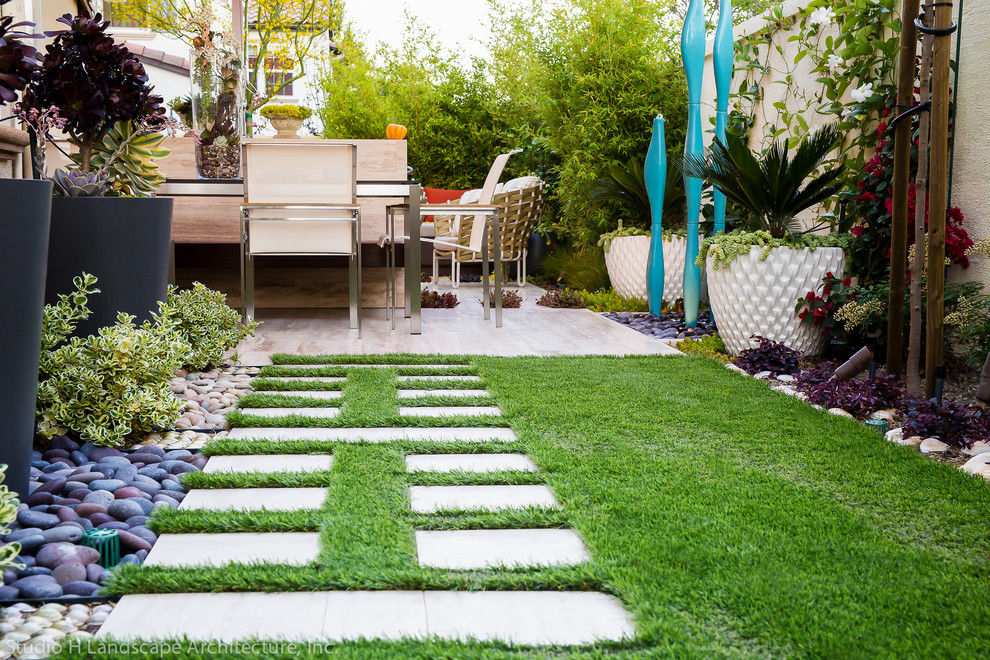 Cette image montre un petit aménagement d'entrée ou allée de jardin arrière minimaliste avec des pavés en pierre naturelle.