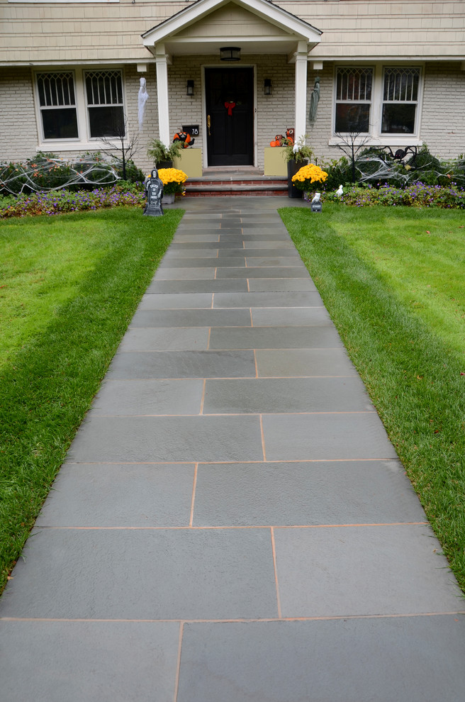 Inspiration for a mid-sized transitional front yard stone garden path in New York.