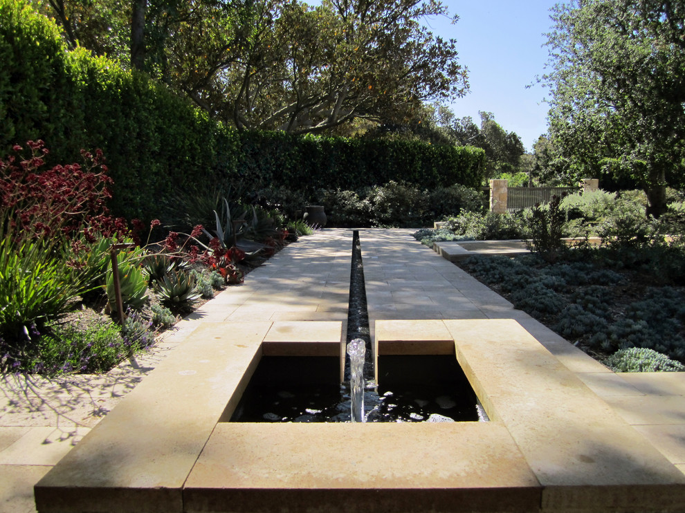 Ispirazione per un grande giardino xeriscape minimalista esposto a mezz'ombra dietro casa in estate con fontane e pavimentazioni in cemento