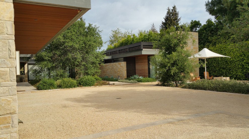 Exempel på en stor modern bakgård i delvis sol som tål torka på sommaren, med en fontän och marksten i betong