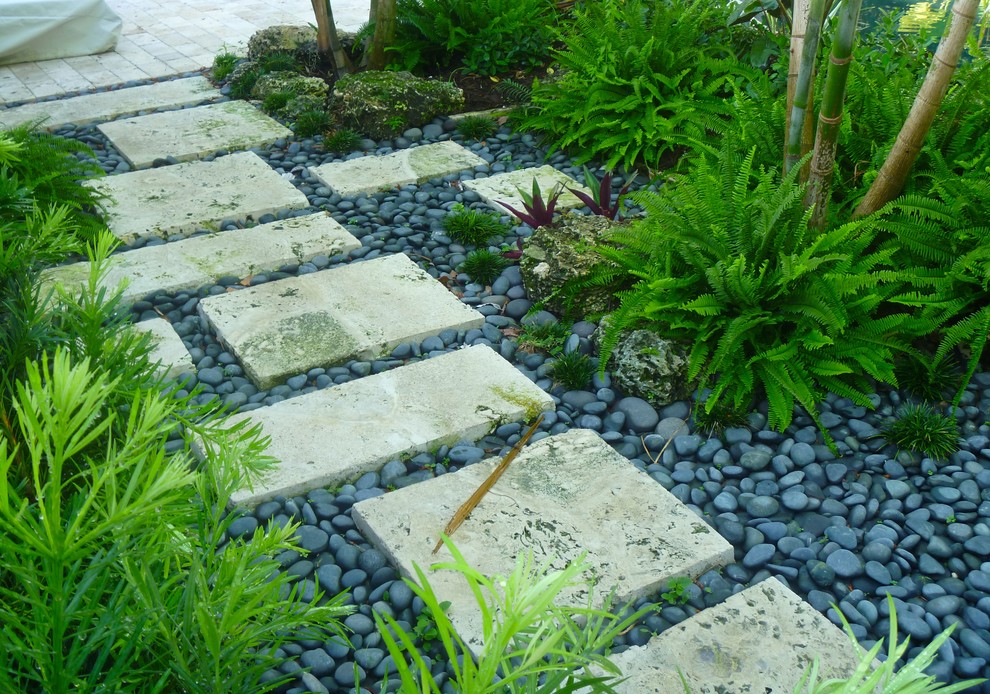 Foto di un giardino tropicale dietro casa con un ingresso o sentiero e pavimentazioni in pietra naturale