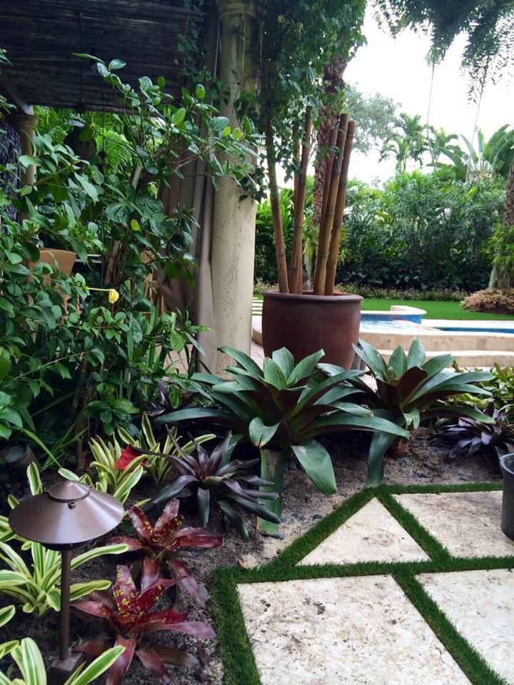 This is an example of an asian partial sun backyard stone landscaping in Miami.