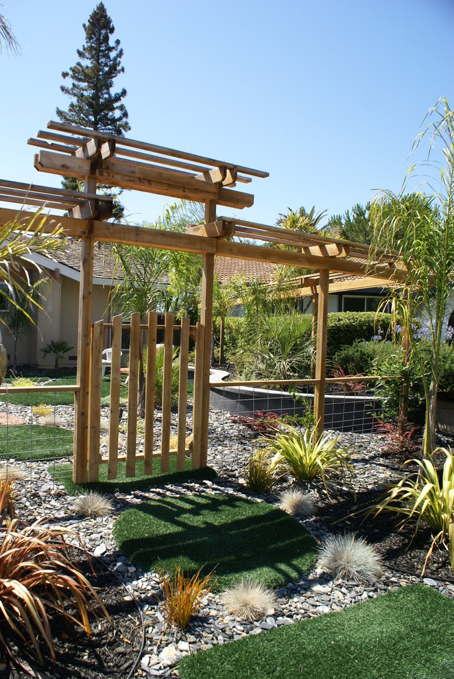 Ejemplo de jardín de secano exótico grande en patio delantero con gravilla