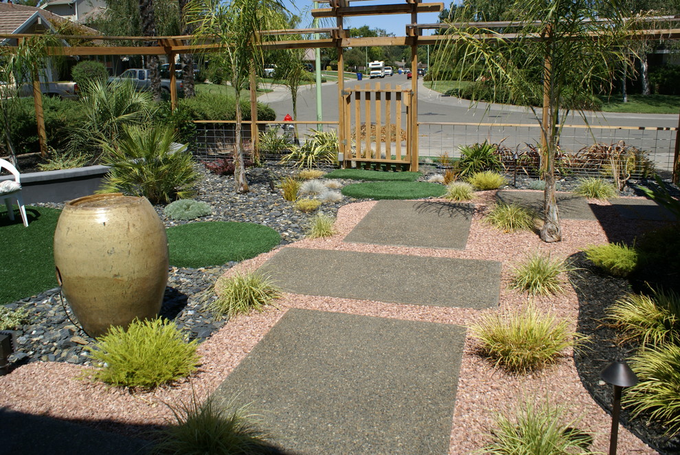 Immagine di un grande giardino xeriscape minimalista davanti casa con un ingresso o sentiero e ghiaia