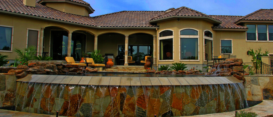 Photo of a large traditional backyard stone landscaping in Austin.