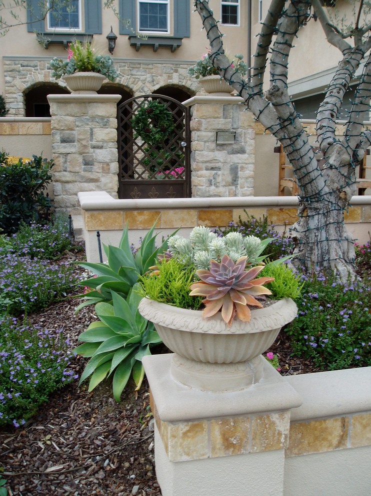 This is an example of a mediterranean sloped garden in San Diego with natural stone paving.