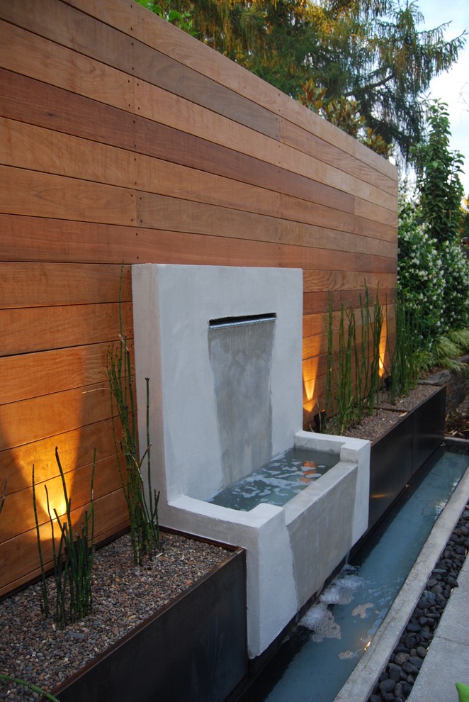 Inspiration för en liten funkis bakgård i delvis sol, med en fontän och marksten i betong