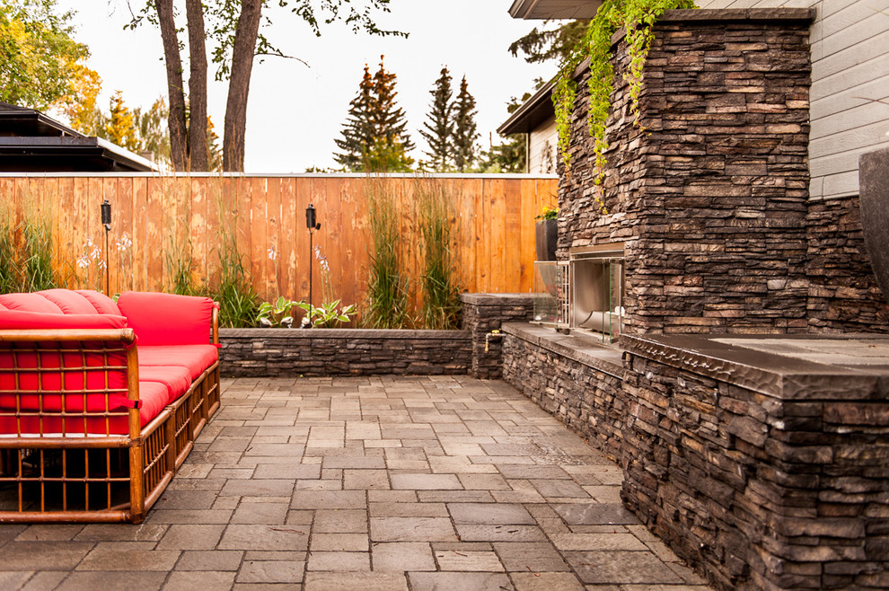 Inspiration for a mid-sized modern backyard brick patio kitchen remodel in Calgary