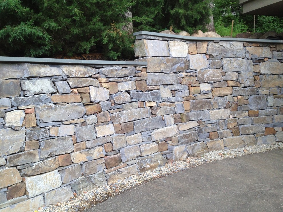 Photo of a large traditional front yard stone retaining wall landscape in Minneapolis.