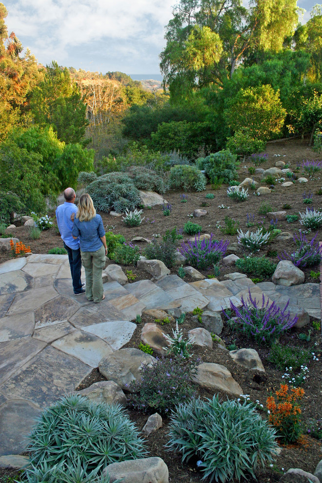 На фото: засухоустойчивый сад среднего размера на склоне в средиземноморском стиле с полуденной тенью и покрытием из каменной брусчатки