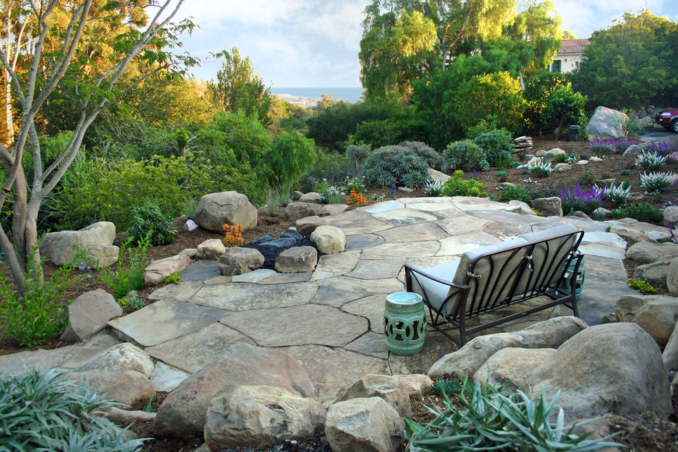 Esempio di un giardino xeriscape mediterraneo esposto a mezz'ombra di medie dimensioni e dietro casa con pavimentazioni in pietra naturale