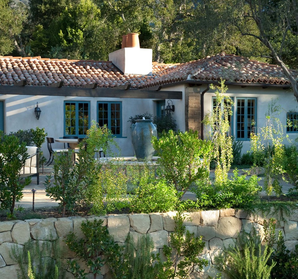 Photo of a mid-sized mediterranean shade backyard stone landscaping in Santa Barbara.