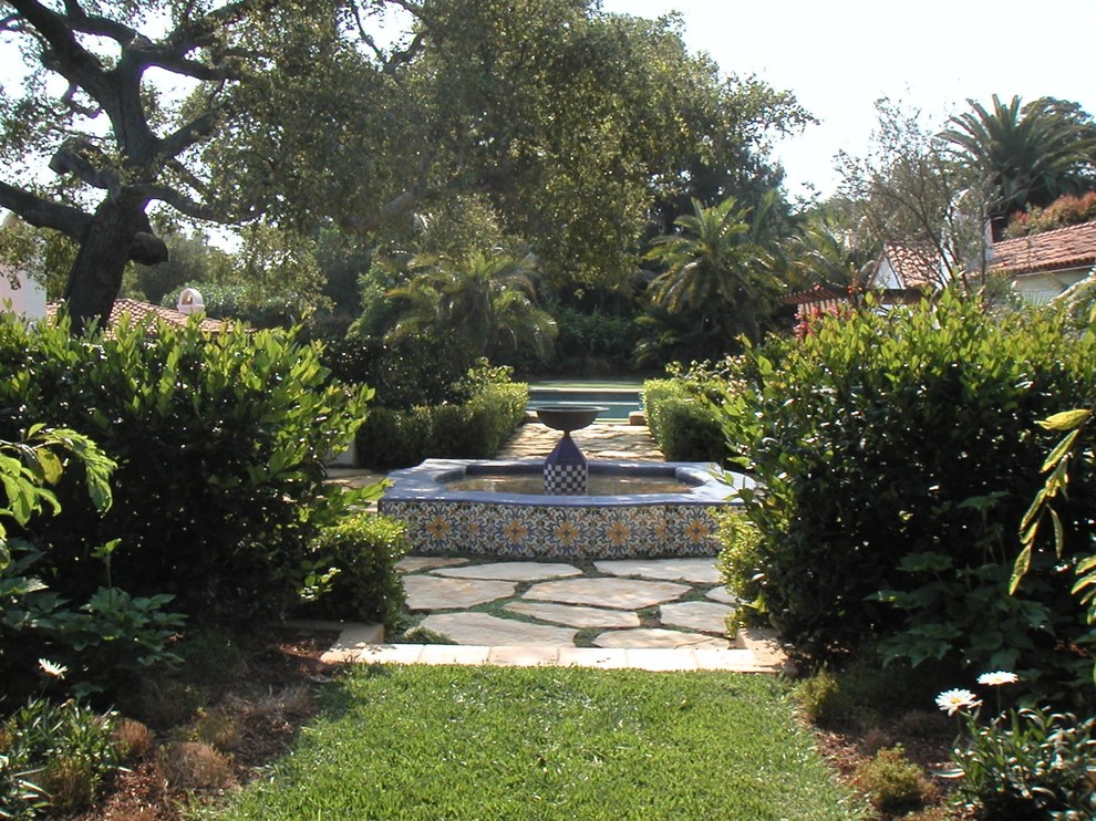 Diseño de jardín mediterráneo grande en patio trasero con jardín francés, estanque y adoquines de ladrillo