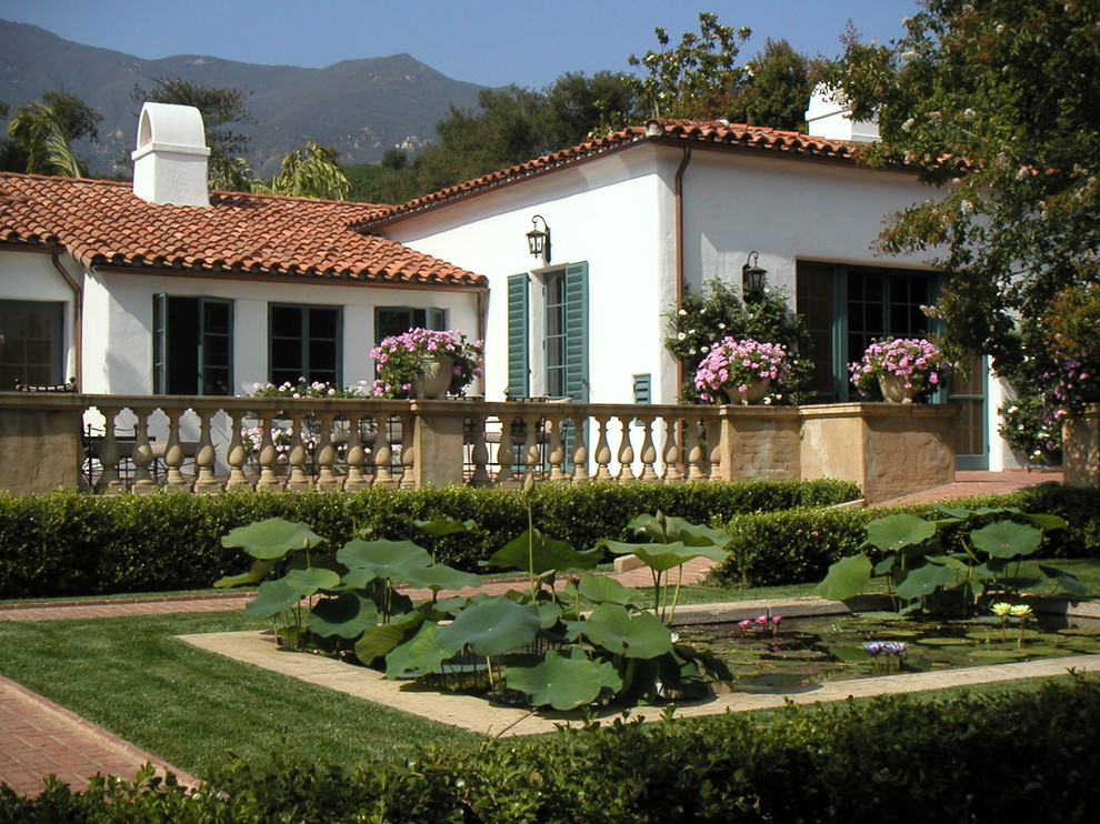Imagen de jardín mediterráneo grande en patio trasero con jardín francés, estanque y adoquines de ladrillo