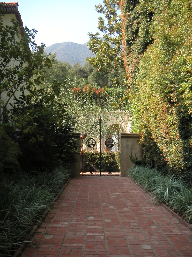 Diseño de jardín mediterráneo grande en patio trasero con jardín francés, estanque y adoquines de ladrillo