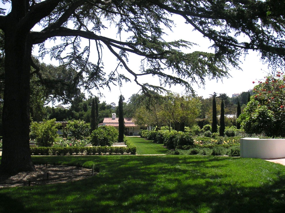 Bild på en mycket stor medelhavsstil trädgård, med en fontän och naturstensplattor
