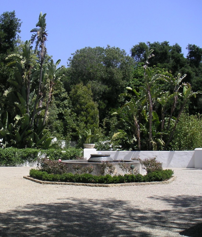 Idéer för en mycket stor medelhavsstil trädgård, med en fontän och naturstensplattor