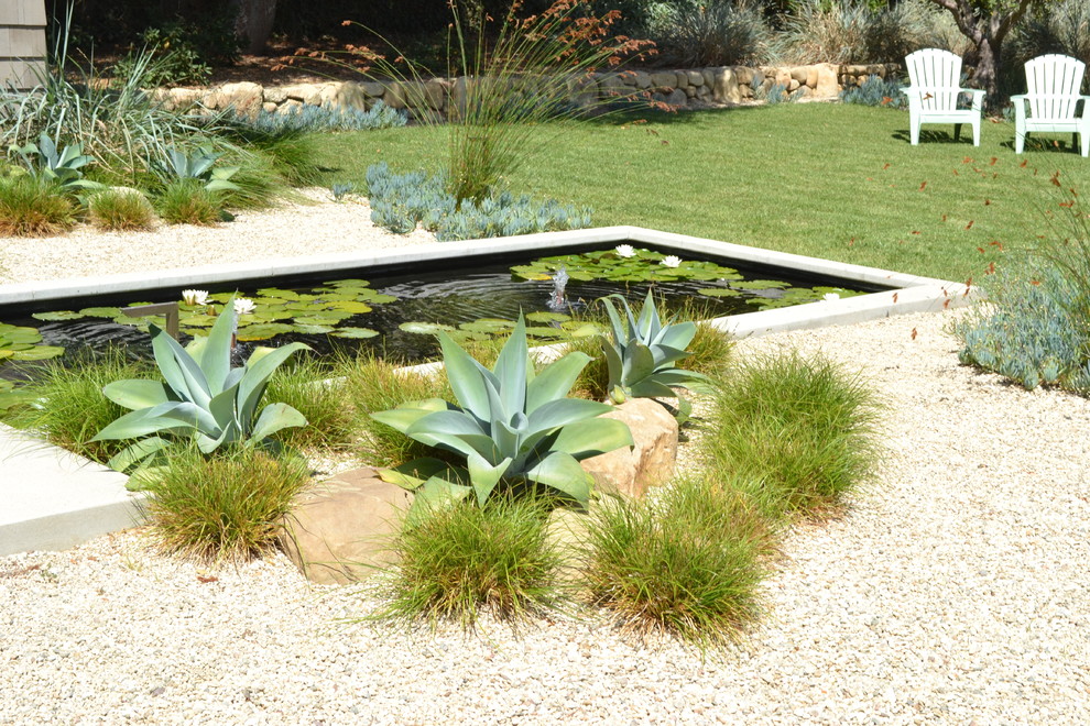 Modelo de jardín actual extra grande en patio trasero con fuente, exposición total al sol y gravilla