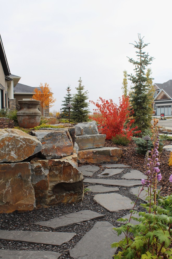 Klassischer Garten im Herbst, hinter dem Haus mit Natursteinplatten und direkter Sonneneinstrahlung in Calgary