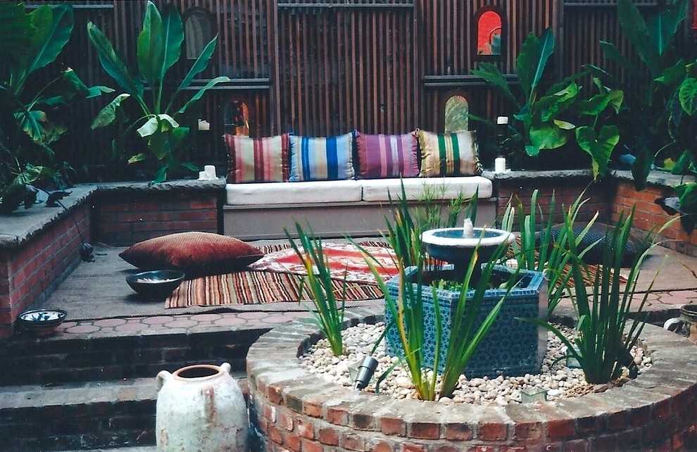 Cette photo montre un jardin sur cour éclectique de taille moyenne et au printemps avec un point d'eau, une exposition partiellement ombragée et des pavés en brique.