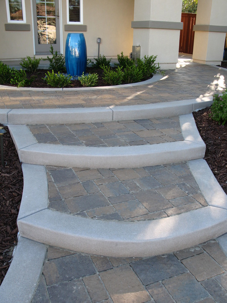 This is an example of a mid-sized mediterranean partial sun front yard concrete paver garden path in San Diego.
