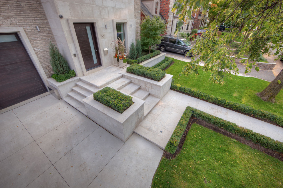 Inspiration for a medium sized contemporary front formal partial sun garden in Toronto with a garden path and natural stone paving.