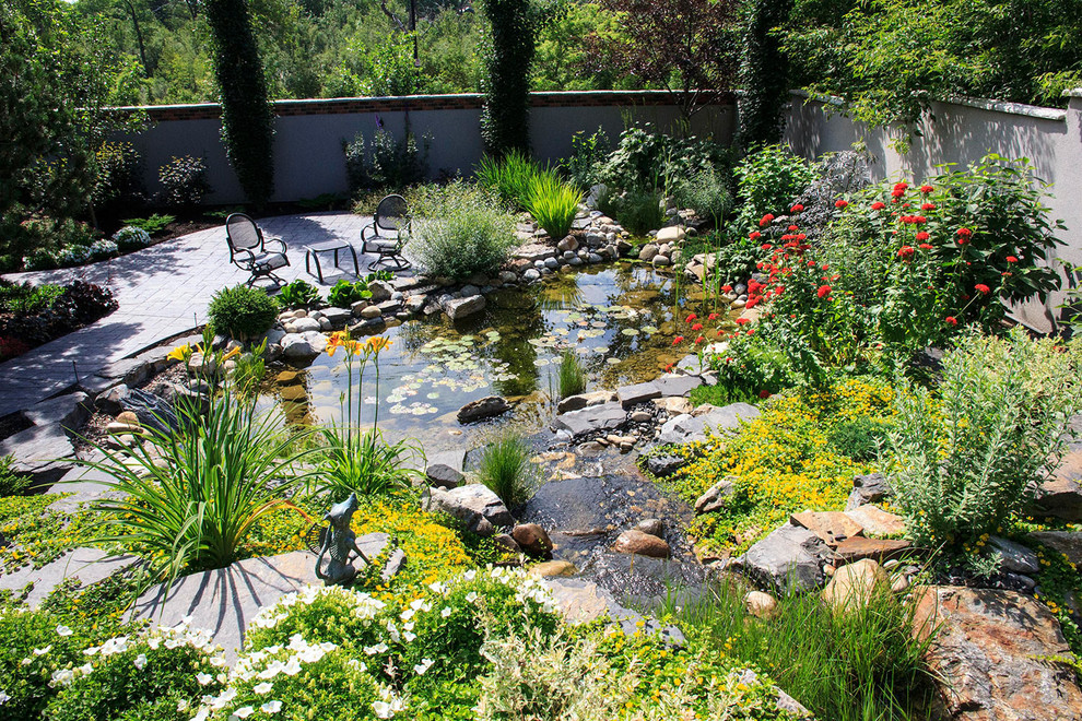 Imagen de jardín bohemio en verano en patio trasero con jardín francés y estanque
