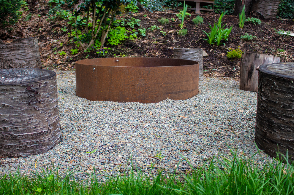 Photo of a medium sized modern back partial sun garden in Portland with gravel and a fire feature.