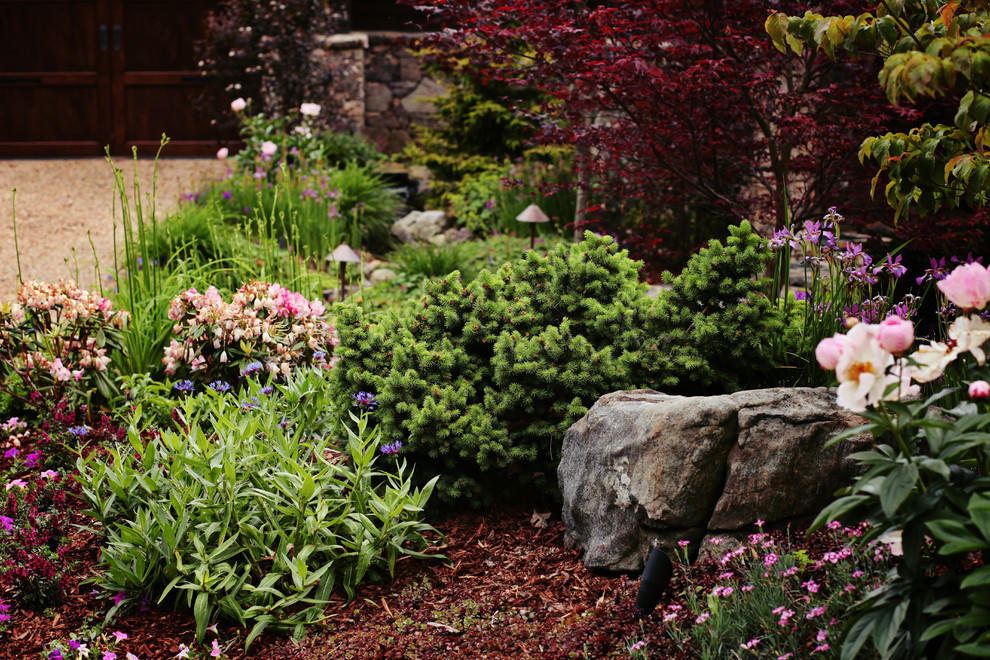 This is an example of a mid-sized traditional partial sun front yard stone formal garden in Charlotte for spring.