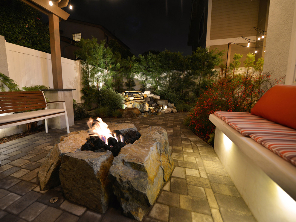 Photo of a medium sized rustic back patio in Los Angeles with a fire feature and concrete paving.