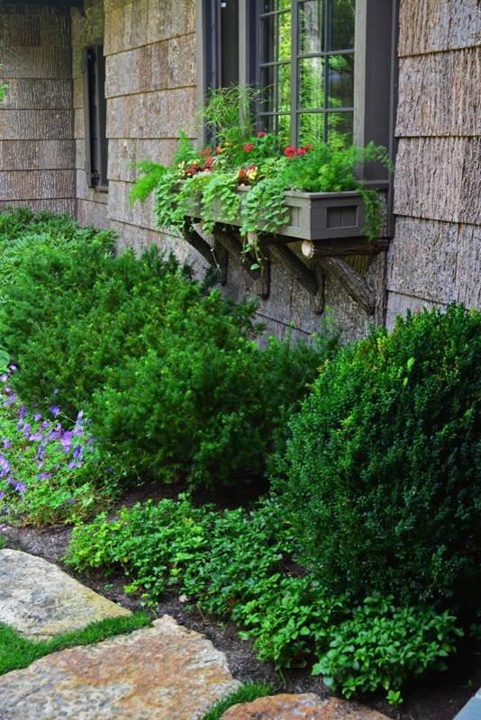 Exemple d'un grand aménagement d'entrée ou allée de jardin avant chic avec une exposition partiellement ombragée et des pavés en pierre naturelle.