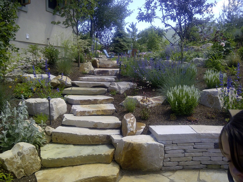 Exemple d'un grand jardin arrière chic avec une exposition partiellement ombragée et des pavés en pierre naturelle.