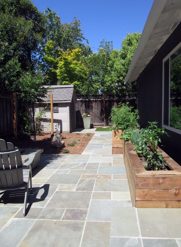 Immagine di un giardino xeriscape minimalista esposto a mezz'ombra di medie dimensioni e dietro casa in estate con un focolare e pavimentazioni in pietra naturale