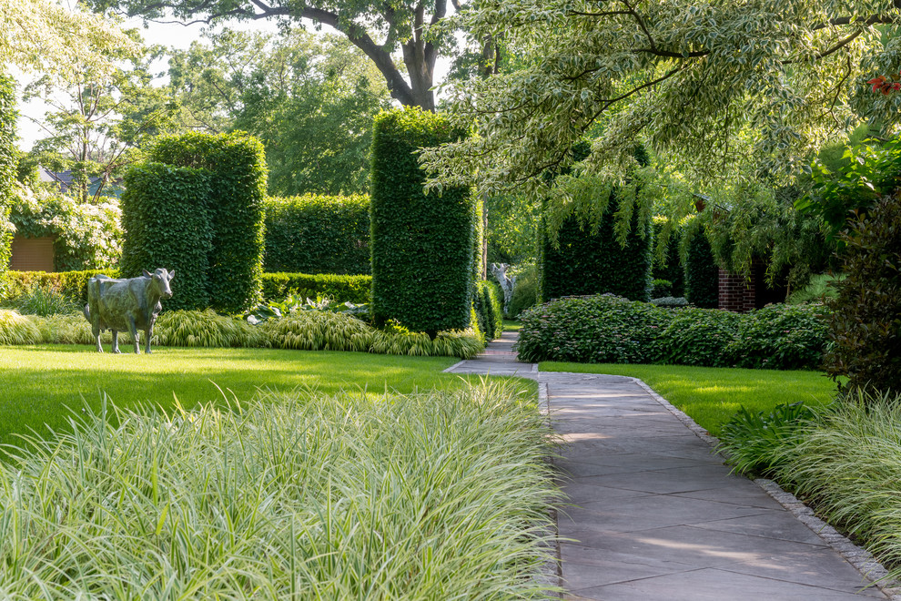 Immagine di un grande giardino formale minimal esposto a mezz'ombra dietro casa in primavera con pavimentazioni in pietra naturale